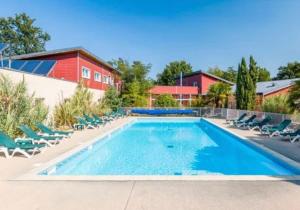 ein Swimmingpool mit Stühlen und einem Gebäude in der Unterkunft Cottage chateau de la loire in Chaveignes