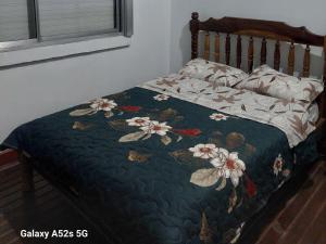 a bed with a quilt with flowers on it at El RINCÓN in Oberá