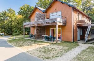 ein Haus mit einer Terrasse mit einem Tisch und Stühlen in der Unterkunft Cottage chateau de la loire in Chaveignes