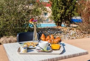 ein Tisch mit einem Tablett mit Essen, Kaffee und Gebäck in der Unterkunft Cottage chateau de la loire in Chaveignes