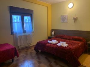 una camera d'albergo con due letti e una finestra di Hotel Miramonti Seulo Turismo Rurale a Seùlo