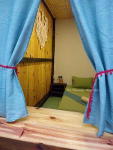 a bedroom with a bed with a blue curtain at Một Homestay Mang Den in Kon Von Kla