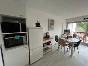 キブロンにあるPlages et Centre Ville à pieds...のキッチン(白い冷蔵庫、テーブル、椅子付)