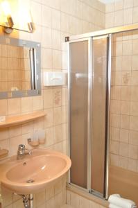ein Bad mit einer Dusche und einem Waschbecken in der Unterkunft Alemannenhof Hotel Engel in Rickenbach