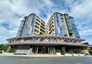a tall building with a city hub on a street at Baguio Condo - City Hub - Urban Oasis in Pines with Pool & Mountain View in Baguio