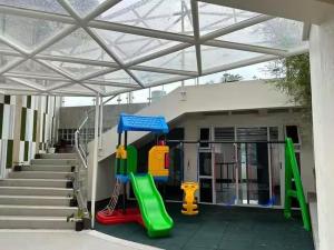 a playground in front of a building with stairs at Baguio Condo - City Hub - Urban Oasis in Pines with Pool & Mountain View in Baguio