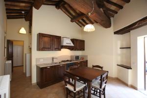 a kitchen with wooden cabinets and a table with chairs at B&B La Chioca in Cingoli