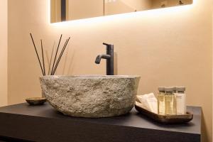 un lavandino in bagno con una ciotola in pietra su un bancone di My Home For You - Città Alta a Bergamo Altre 37 foto