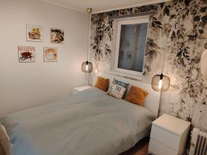 a bedroom with a bed and two tables and a window at Pupi Apartmanház in Balatonlelle