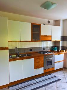 a kitchen with white cabinets and a sink and a stove at Casa nel centro di Cembra in Cembra +4 photos