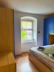 a bedroom with a bed and a window at Casa nel centro di Cembra in Cembra
