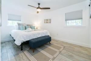 Un dormitorio blanco con una cama y un ventilador de techo. en Hot Tub 5 min to beach King Bed, en St. Augustine