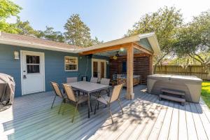 una terraza de madera con mesa y bañera de hidromasaje en Hot Tub 5 min to beach King Bed, en St. Augustine