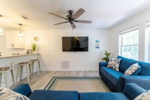 sala de estar con sofá azul y ventilador de techo en Hot Tub 5 min to beach King Bed, en St. Augustine