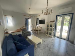 a living room with a blue couch and a table at Villa Joseph in Agia Fotia