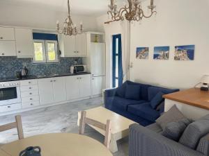 a living room with a blue couch and a kitchen at Villa Joseph in Agia Fotia