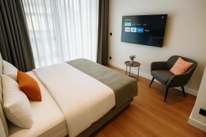 a bedroom with a bed and a chair and a television at Center Port Hotel Karaköy in Istanbul +28 photos
