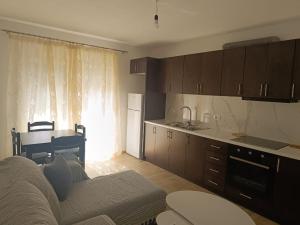 a living room with a couch and a kitchen at close to beach with balcony in Sarandë