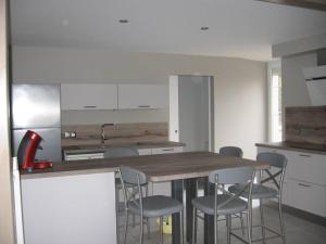 Una cocina con una mesa y sillas de madera. en Gîte de Romagers, en La Chaze-de-Peyre