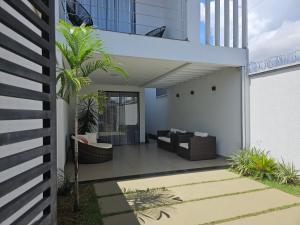 eine Terrasse eines Hauses mit einem Sofa und einer Palme in der Unterkunft apto. moderno, perto faculdades ulbra e católica. in Palmas