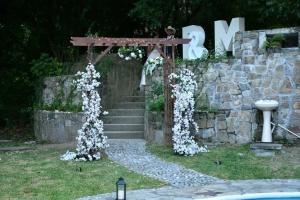 un arco con fiori bianchi accanto a un muro di pietra di quinta esperanza a Santiago