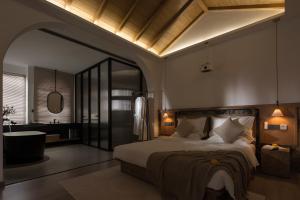 a bedroom with a large bed and a bathroom at SIXI Conglu Design Aesthetics Hotel in Lijiang