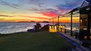 a house with a view of the ocean at sunset at Brenton Haven Beachfront Resort in Knysna