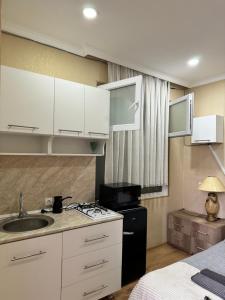 a kitchen with white cabinets and a sink and a stove at Kesane in Telavi +47 photos
