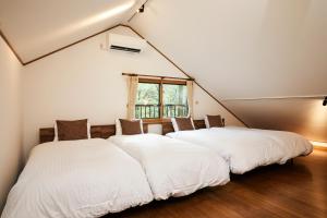 two white beds in a room with a window at Noël Kitakaruizawa Seiryu-2 Riverside retreat in Tsumagoi