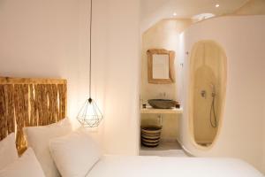 a white bedroom with a bed and a sink at Casa Centro Suites Mykonos in Mikonos