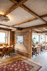 jadalnia z drewnianymi ścianami i stołami oraz dywanem w obiekcie Hotel La Montanina w Livigno