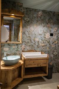 łazienka z wanną, umywalką i kwiatami w obiekcie Hotel La Montanina w Livigno +37 zdjęć