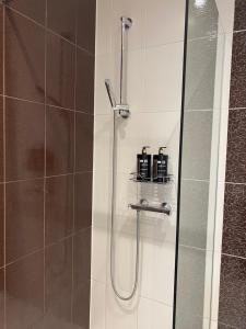 a bathroom with a shower with a glass door at Compass apartment in Tallinn +11 photos
