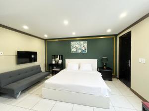 a bedroom with a large bed and a couch at La Casona- Phú Mỹ Hưng in Ho Chi Minh City
