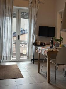 sala de estar con mesa y vistas a un balcón en - Seaside Nest-Free Parking & Beach, en Marina di Carrara