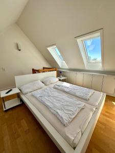 a bedroom with a large white bed with two skylights at 7034 Enseling in Dahme