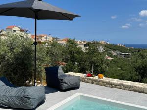 una piscina con dos sillas y una sombrilla en Villa Maria, en Stalós