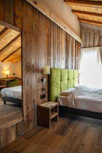 sypialnia z 2 łóżkami i zielonym zagłówkiem w obiekcie Hotel La Montanina w Livigno