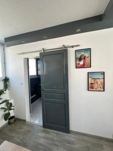 a bathroom with a black door and two pictures on the wall at Appartement hyper-centre Stella in Dunkerque
