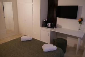 a room with a desk with a tv and a chair at Le Tre Gemme - Luxury Rooms in Ravenna