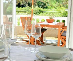 a table with wine glasses and a bowl on it at Apartman Rabtours in Kampor