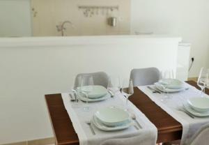 a dining room table with plates and wine glasses at Apartman Rabtours in Kampor