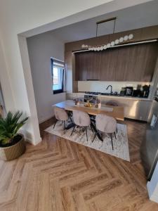 a kitchen with a wooden table and some chairs at Daric Residence Penthouse Apartament in Fălticeni