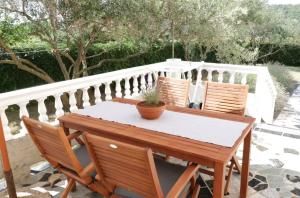 a wooden table and two chairs on a balcony at Apartman Rabtours in Kampor