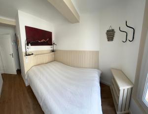 ein Schlafzimmer mit einem weißen Bett in einem Zimmer in der Unterkunft Charming and very central 2 rooms apartment in Bandol