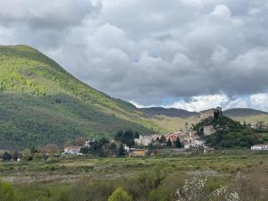 a small town on a hill with mountains in the background at La Casetta in Pescolanciano