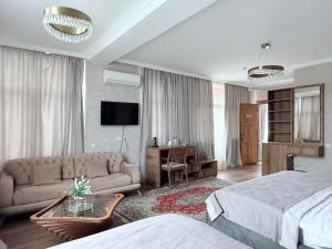 a bedroom with a bed and a couch and a tv at Boutique Hotel Tbili in Tbilisi City