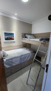 Flat na Passagem -CF- في كابو فريو: غرفة نوم مع سرير بطابقين وكرسي