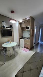 Flat na Passagem -CF- في كابو فريو: غرفة معيشة بها طاولة ومطبخ