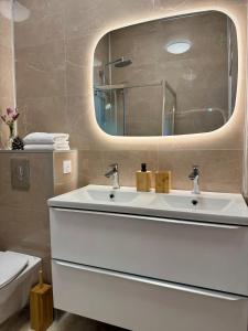Un baño con un lavabo blanco y un espejo. en Villa with stunning views, en Cap d'Ail